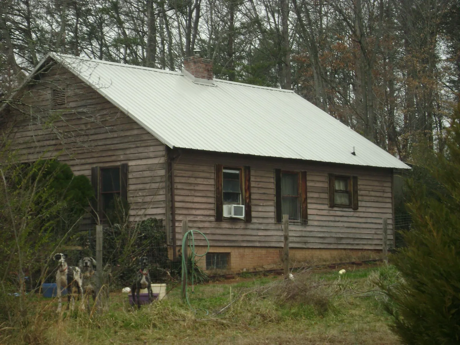 White metal roof on an old wood sided farmhouse, from a Metal Roof Installation job in Clatonia